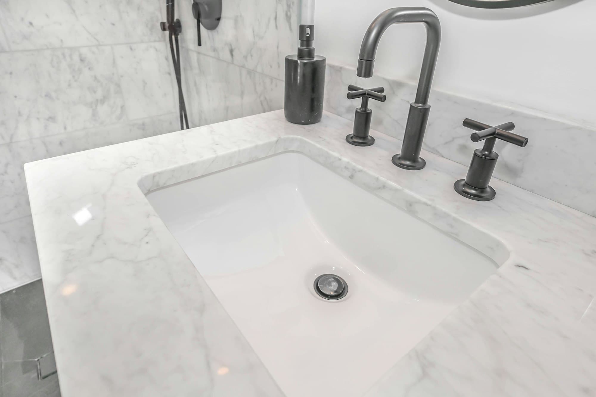 A marble bathroom vanity with an undermount sink and black faucet.